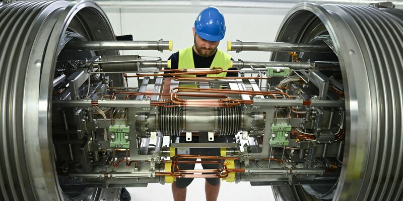 Techniker aus dem In- und Ausland montieren riesige Magnete. - Foto: Arne Dedert/dpa