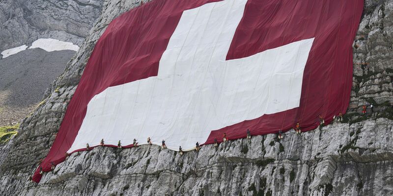 Anfang August wird am Säntis eine riesige Schweizerfahne zum Nationalfeiertag angebracht und danach wieder abgebaut. Höhenarbeiter beteiligten sich am Rettungseinsatz. - Foto: Gian Ehrenzeller/KEYSTONE/dpa