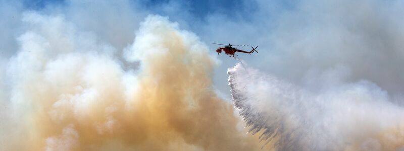 Noch immer flammen neue Brandherde auf, bekämpft wird auch aus der Luft. - Foto: Marios Lolos/XinHua/dpa