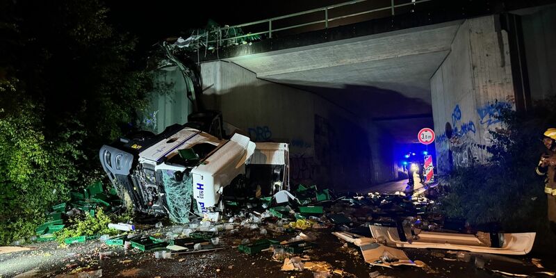Ein Lkw ist von einer Autobahnbrücke auf eine darunterliegende Straße gestürzt.  - Foto: Christian Müller/Westfalennews/dpa