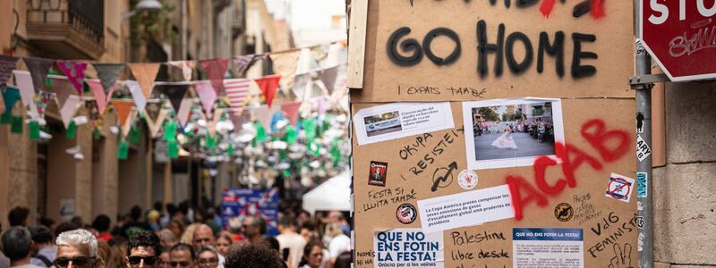 «Tourists go home» beziehungsweise «Tourism go home» steht an einer Wand in Barcelona (August 2024). - Foto: Marc Asensio Clupes/ZUMA Press Wire/dpa