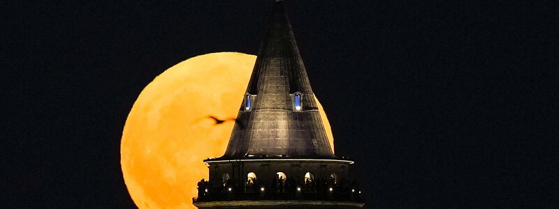 Ein Supermond geht hinter dem Galata-Turm in Istanbul auf. - Foto: Khalil Hamra/AP/dpa