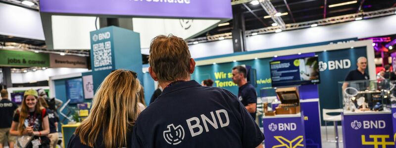 Mitarbeiter des BND stehen am Gamescom-Messestand ihrer Behörde. Die Bundesbehörde zählt circa 6.500 Beschäftigte. - Foto: Oliver Berg/dpa