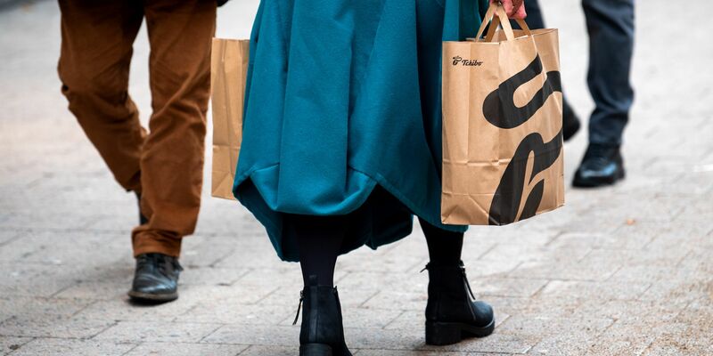 Eine Frau mit Einkaufstüten geht durch die Hamburger Innenstadt. - Foto: Daniel Bockwoldt/dpa