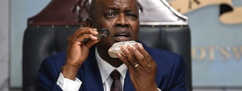 Botswanas Präsident Mokgweetsi Masisi begutachtet den vermutlich zweitgrößten Rohdiamant der Welt, der in seinem Land entdeckt wurde. Der Edelstein ist etwa so groß wie eine Avocado und wiegt 2.492 Karat. - Foto: Uncredited/AP/dpa