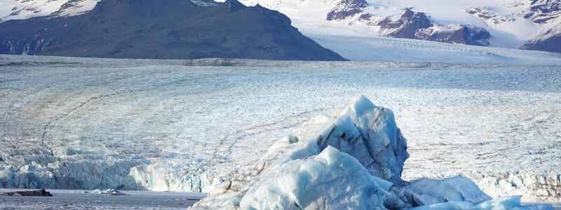 Kleines Boot, mächtiges Eis: Touristen fahren auf der Gletscherlagune Jökulsarlon an einem Eisberg vorbei. (Archivbild) - Foto: Owen Humphreys/PA Wire/dpa