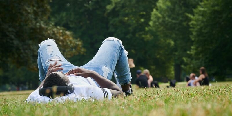 Musik hören im Park auf der Wiese - mehr Sommer geht kaum. Was wird der Sommerhit '24? (Illustration) - Foto: Annette Riedl/dpa