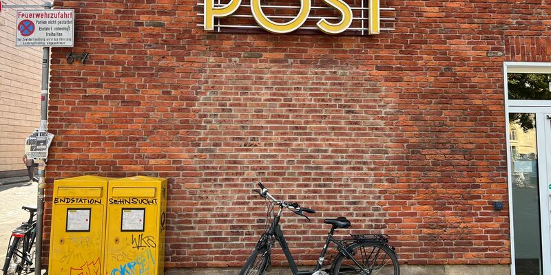 Eine Briefträgerin fährt an einer Postfiliale vorbei - vielleicht ist auch sie eine Beamtin? - Foto: Wolf von Dewitz/dpa