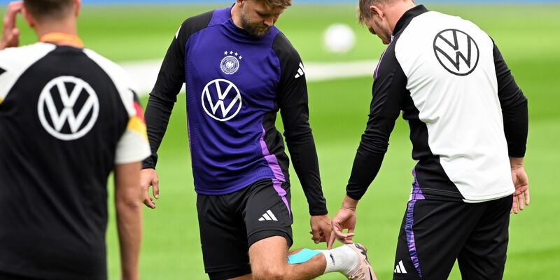 Niclas Füllkrug (M) nach seinem vergeblichen Härtetest beim Abschlusstraining im Gespräch mit Bundestrainer Julian Nagelsmann (r). - Foto: Federico Gambarini/dpa