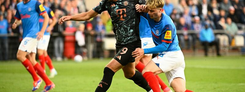 Bayerns Harry Kane (l-r) behauptet den Ball gegen Kiels Finn Porath. - Foto: Gregor Fischer/dpa