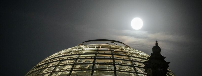 Der Vollmond leuchtete hell über der Kuppel des Reichstagsgebäudes. - Foto: Kay Nietfeld/dpa