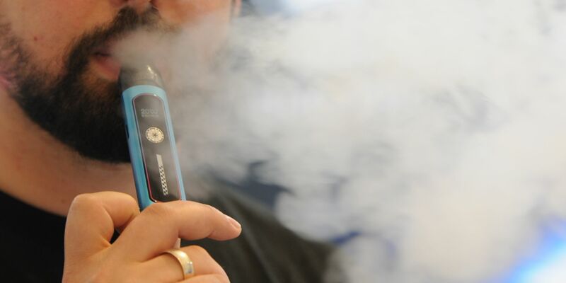 Ein Mann inhaliert bei der Fachmesse Intertabac eine Mehrweg-E-Zigarette. - Foto: Wolf von Dewitz/dpa