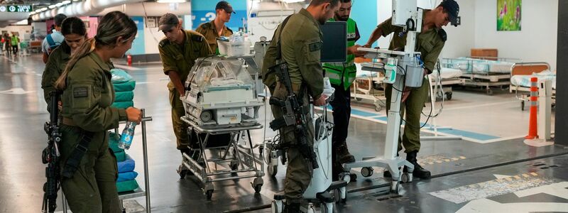 Krankenhauspersonal und Soldaten bringen Patienten und Ausrüstung in die unterirdische Station der Rambam-Klinik. - Foto: Ohad Zwigenberg/AP/dpa