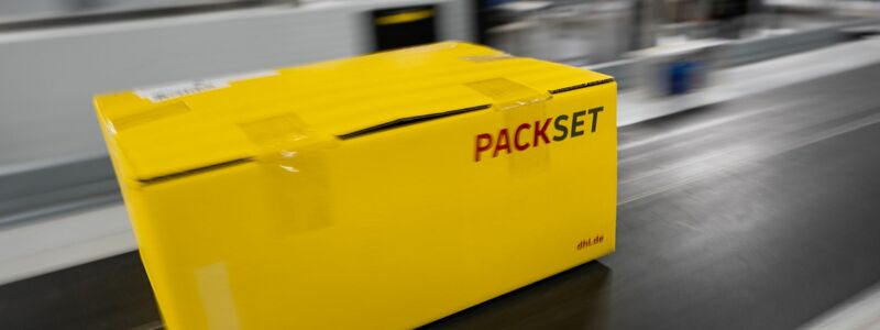 Ein Paket rollt über das Laufband eines DHL-Paketzentrums. - Foto: Christophe Gateau/dpa