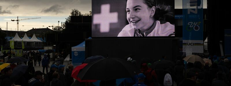 Trauer um Muriel Furrer: Ihr Foto wird auf einer Großbildleinwand gezeigt. - Foto: Peter Dejong/AP/dpa