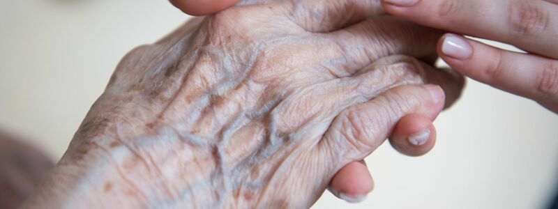 Alt und Jung: Eine Pflegerin hält die Hand einer Bewohnerin im Seniorenzentrum. Aber wie lange kann dieses Versorgungssystem noch funktionieren? (Symbolbild) - Foto: Christophe Gateau/dpa