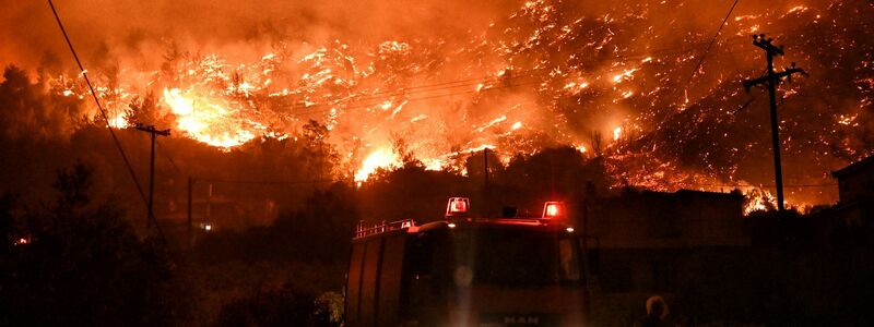 Flammen färben den Himmel glutrot. - Foto: Uncredited/AP