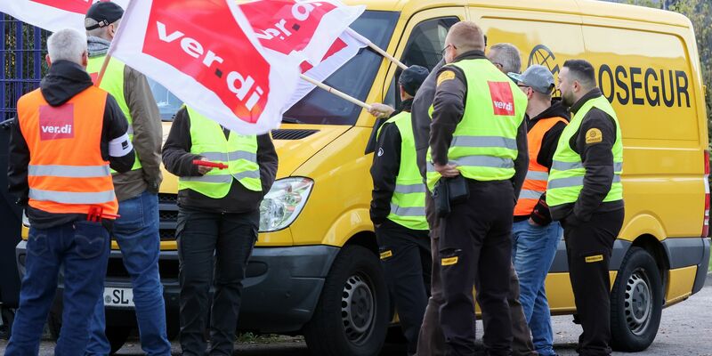 Teilnehmer eines Streiks stehen vor einer Niederlassung von Prosegur in Hamburg. - Foto: Bodo Marks/dpa