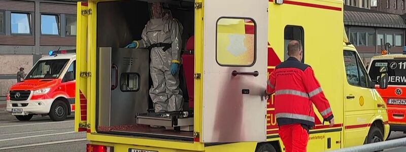 Einsatzkräfte mit Mundschutz begleiten zwei Menschen zum Rettungswagen der Feuerwehr vor dem Hauptbahnhof. - Foto: André Lenthe/Lenthe Medien/dpa