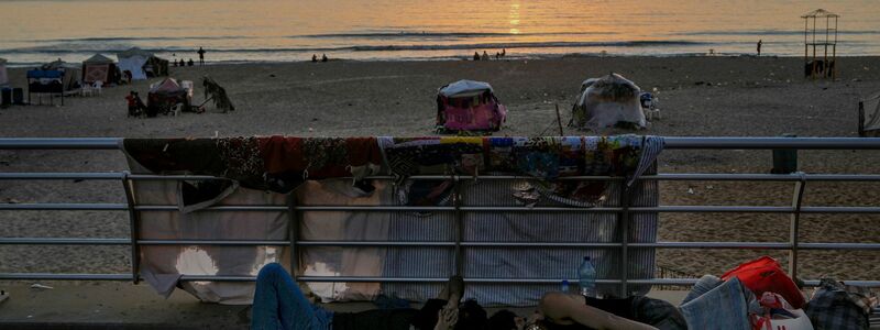 Männer schlafen am öffentlichen Strand. - Foto: Bilal Hussein/AP