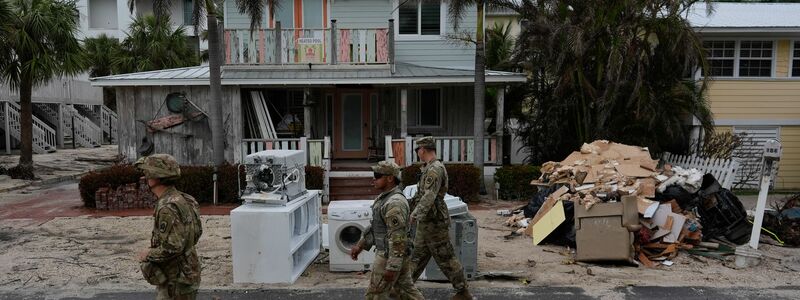 Nationalgardisten suchen nach verbliebenen Bewohnern im fast menschenleeren Bradenton Beach. Den Anwohnern blieb nach Hurrikan «Helene» keine Zeit, die Schuttberge zu beseitigen.  - Foto: Rebecca Blackwell/AP/dpa