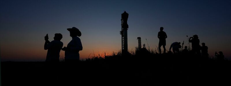 Menschen fotografieren den Sonnenuntergang hinter der Rakete Starship von SpaceX. - Foto: Eric Gay/AP