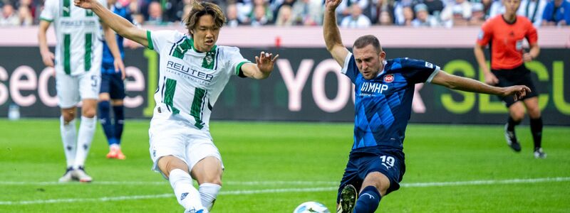 Der Mönchengladbacher Ko Itakura (l) trifft in dieser Szene zum 1:1, Heidenheims Jonas Föhrenbach grätscht zu spät dazwischen. - Foto: David Inderlied/dpa