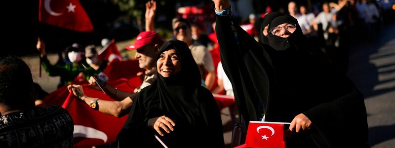 Menschen halten türkische Flaggen hoch, während sie sich zu Ehren der Opfer des gescheiterten Putschversuchs vom 15. Juli 2016 versammelten. (Archivbild) - Foto: Francisco Seco/AP/dpa