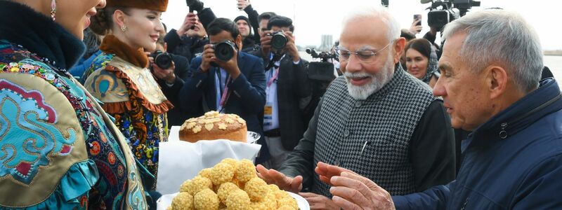 Der indische Premierminister Narendra Modi (2. v. r.) probiert bei seiner Ankunft am Flughafen von Kasan eine traditionelle tatarische Süßigkeit.  - Foto: Ilya Pitalev/brics-russia2024.ru via AP/dpa