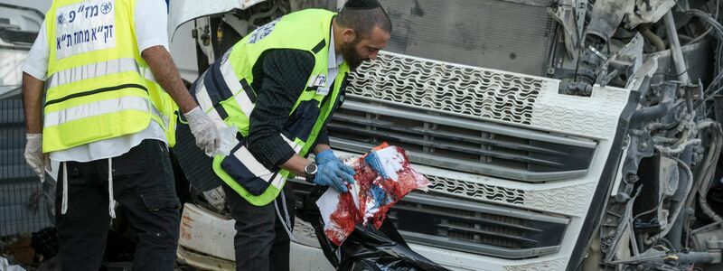 Mitglieder des Rettungs- und Bergungsteams Zaka arbeiten an der Stelle, an der ein Lkw-Fahrer eine Bushaltestelle gerammt und dabei Dutzende von Menschen verletzt hat. - Foto: Oded Balilty/AP