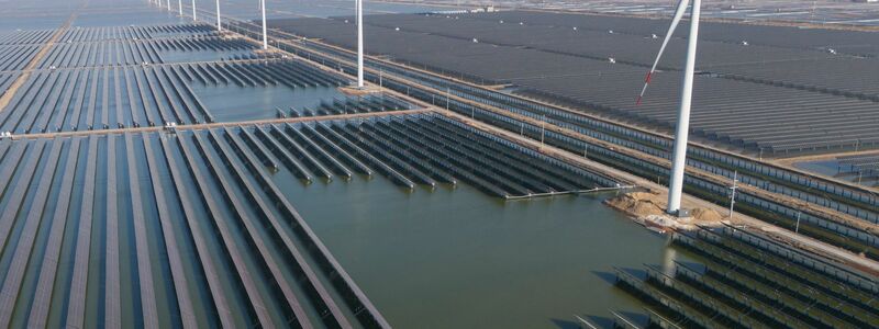 Windräder drehen sich auf einem riesigen Solarpark in China. (Archivbild) - Foto: Ng Han Guan/AP/dpa