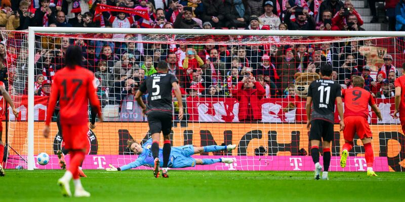 Harry Kane (r) schießt den Elfmeter in die Ecke, die ihm Union-Torwart Frederik Rönnow anzeigte. - Foto: Tom Weller/dpa