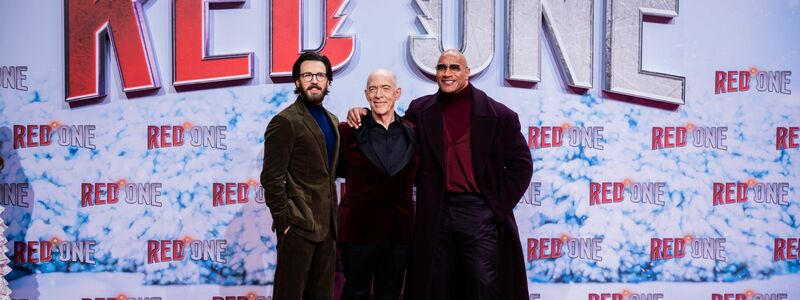 Chris Evans (l-r), J.K. Simmons und Dwayne Johnson auf dem Roten Teppich zur Weltpremiere des Films «Red One – Alarmstufe Weihnachten».  - Foto: Christoph Soeder/dpa