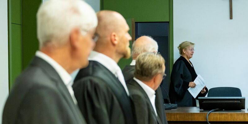 Die Angeklagten mit ihren Verteidigern zu Prozessbeginn. Im Hintergrund die Vorsitzende Richterin. - Foto: Lennart Preiss/dpa