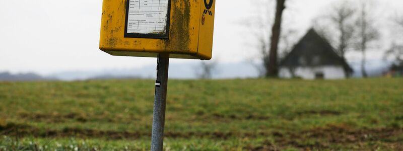 Ein Briefkasten der Deutschen Post steht auf einer Wiese am Rand einer Siedlung im Bergischen Land (NRW).  - Foto: Oliver Berg/dpa