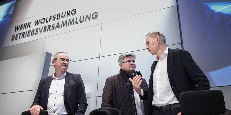 Konzernchef Oliver Blume (r.) berät sich vor seiner Rede mit VW-Verhandlungsführer Arne Meiswinke (Mitte). - Foto: Ronny Hartmann/POOL/dpa