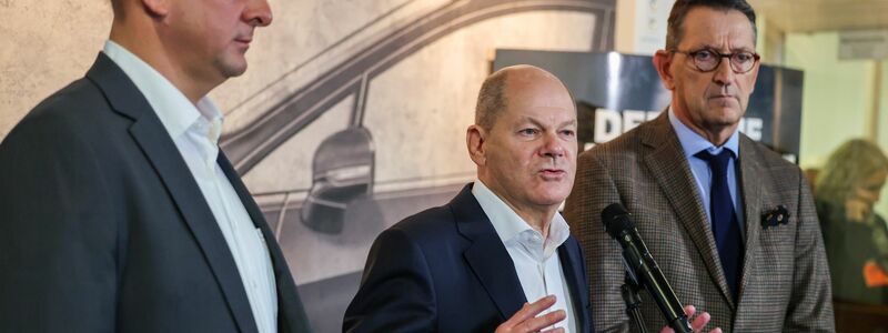 Betriebsratschef Benjamin Gruschka (l) neben Bundeskanzler Olaf Scholz (SPD) und Marcus Wassenberg (r), Geschäftsführer der Ford-Werke. - Foto: Christoph Reichwein/dpa