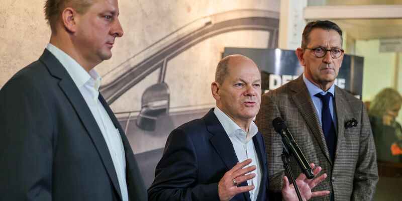 Benjamin Gruschka (links), Betriebsratschef Ford Deutschland, steht neben Bundeskanzler Olaf Scholz (SPD) und Marcus Wassenberg, Geschäftsführer der Ford-Werke. - Foto: Christoph Reichwein/dpa