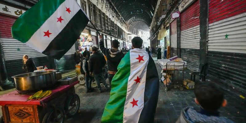 Anhänger der Opposition tragen Oppositionsfahnen. - Foto: Hussein Malla/AP/dpa