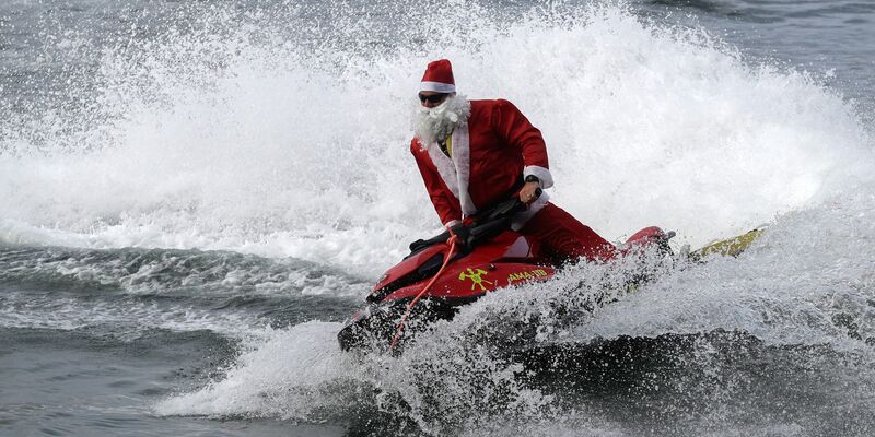 Für die Kinder gab es Geschenke vom Jetski aus. - Foto: Bruna Prado/AP Photo/dpa