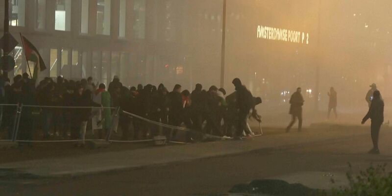 In diesem Videostandbild werfen pro-palästinensische Demonstranten eine Metallbarriere in der Nähe des Fußballstadions in Amsterdam um. (Archiv) - Foto: RTL Nieuws/RTL Nieuws/AP/dpa