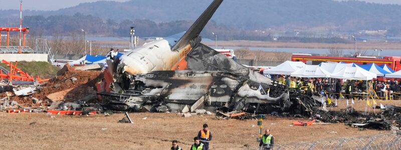 Feuerwehrleute und Rettungskräfte suchen am Wrack des verunglückten Flugzeugs auf dem internationalen Flughafen von Muan nach Opfern.  - Foto: Ahn Young-joon/AP/dpa