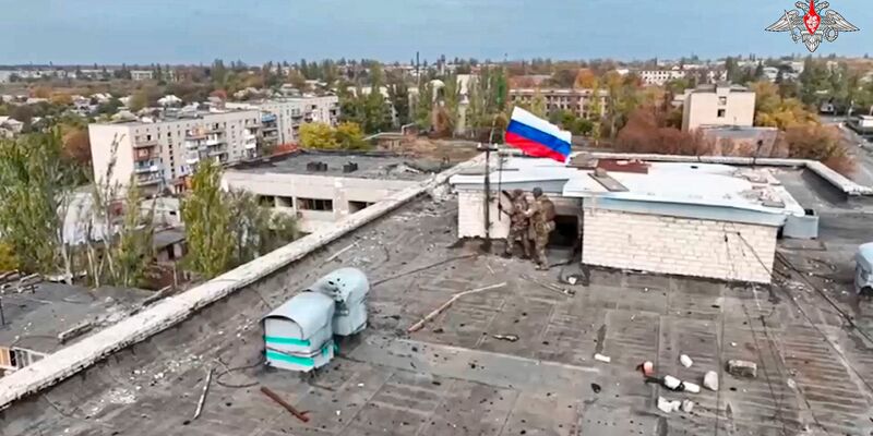 Russische Soldaten hissen in einer Ortschaft auf einem Gebäude eine Fahne nach dessen Einnahme. (Archivbild/Handout)  - Foto: Uncredited/Russian Defense Ministry Press Service/AP/dpa