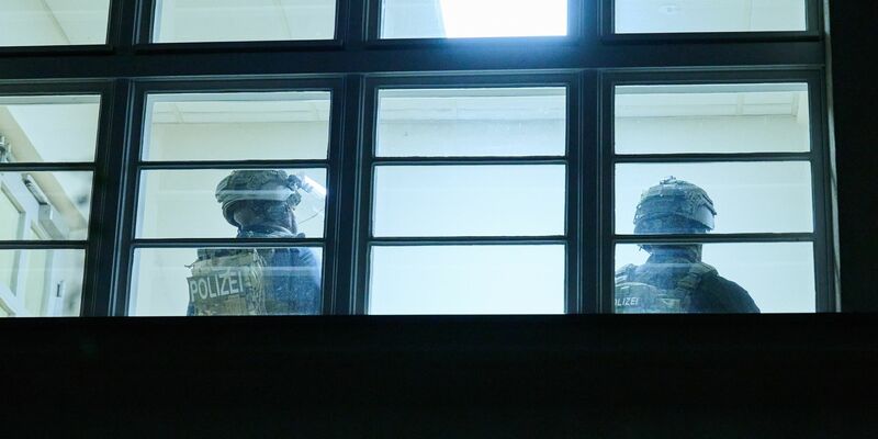 Schwerbewaffnete Polizisten durchsuchen eine Grundschule in Berlin. Doch am Abend kommt Entwarnung. - Foto: Annette Riedl/dpa