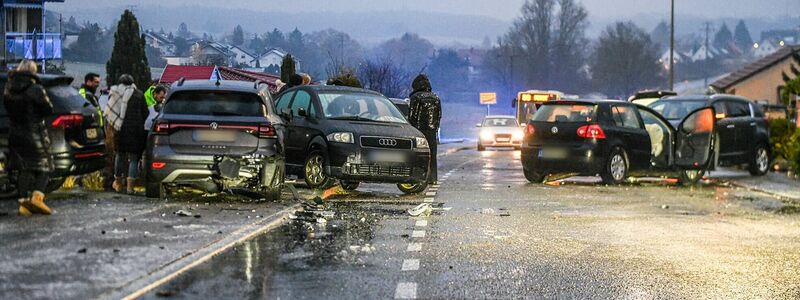 Nach einem Unfall bei Glatteis mit mehreren Fahrzeugen in Baden-Württemberg stehen Helfer und Beteiligte an den Autos auf einer Straße.  - Foto: Jason Tschepljakow/dpa