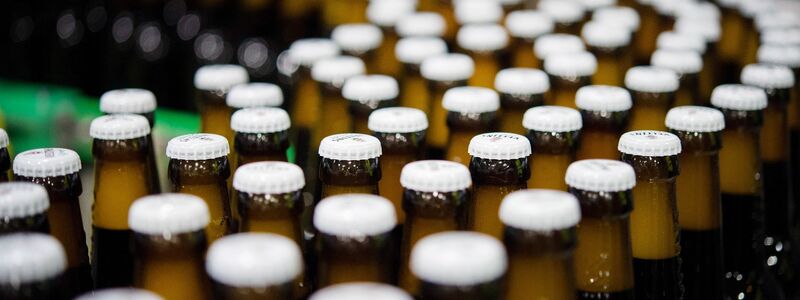 Bierflaschen mit Kronkorken laufen durch die Produktion der Veltins-Brauerei in Meschede-Grevenstein über die Förderbänder einer Befüllungsanlage. - Foto: Rainer Jensen/dpa