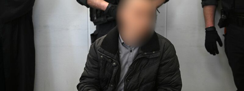 Der wegen Mordes an der neunjährigen Valeriia Angeklagte wird im Landgericht Chemnitz von einem Justizmitarbeiter vorgeführt. - Foto: Hendrik Schmidt/dpa