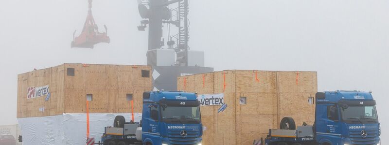 Verpackt in riesigen Holzkisten werden die Teile des Teleskops in Wesel auf ein Schiff geladen. - Foto: Christoph Reichwein/dpa