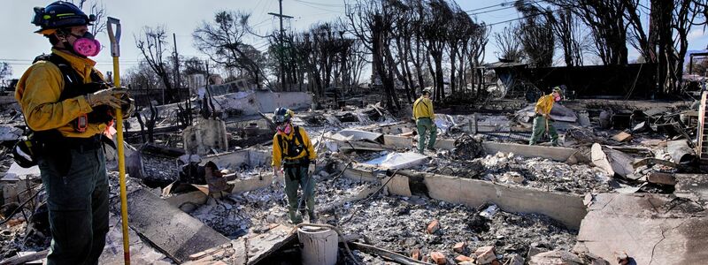 In den Brandruinen wird auch noch nach möglichen Opfern gesucht.  - Foto: Richard Vogel/AP/dpa