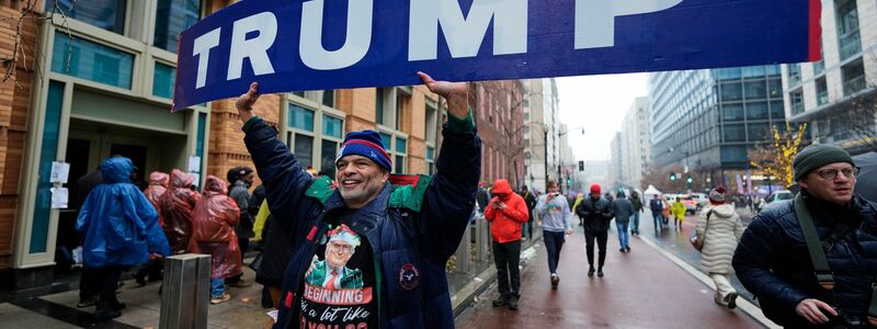 Dieser Straßenverkäufer wird vor der Arena, in der Trump später spricht, einiges an Merchandise-Artikeln los. - Foto: Mike Stewart/AP/dpa